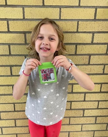 A 2nd grade student holding her finished magnet