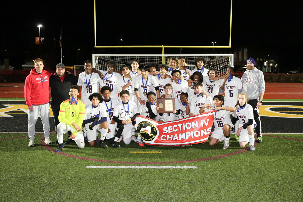 binghamton boys soccer team posing with section IV championship banner