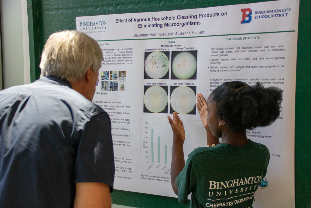 student explains her research experiment to a visitor at the annual Go Green Institute