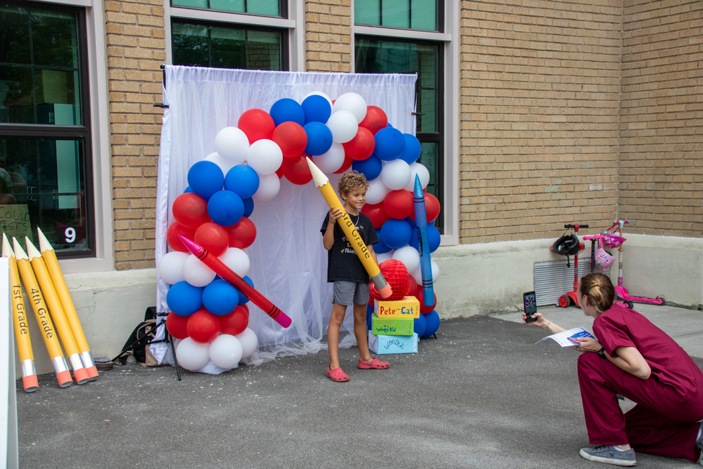 student poses for photo holding large cardboard pencil
