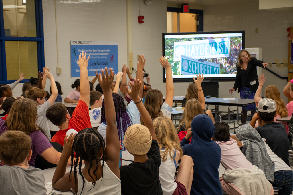 students raise hands during assembly at thomas jefferson