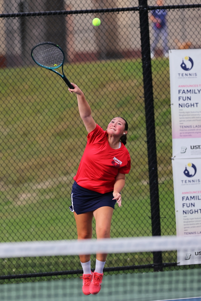 tennis player serves ball