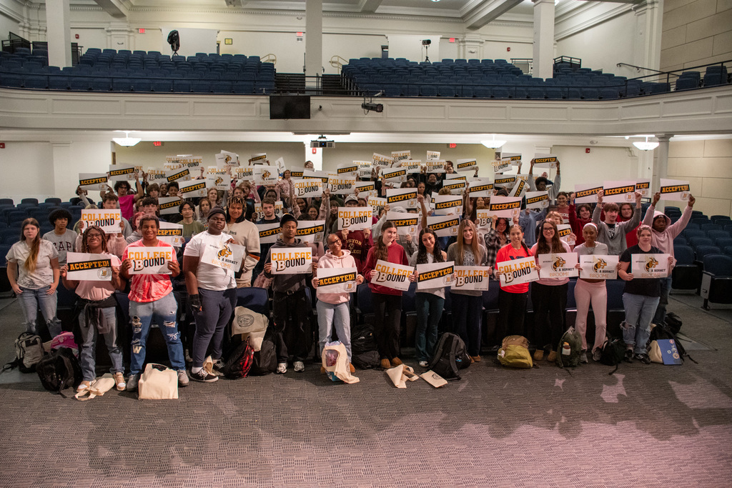 binghamton high school students hold signs indicating that they have been accepted to SUNY Broome