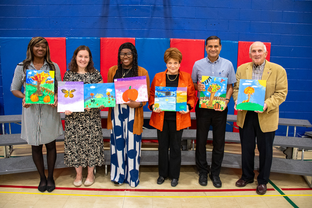 board of education members holding artwork made by horace mann students