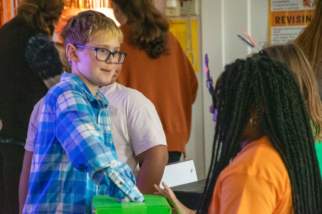 student reaches into sensory box