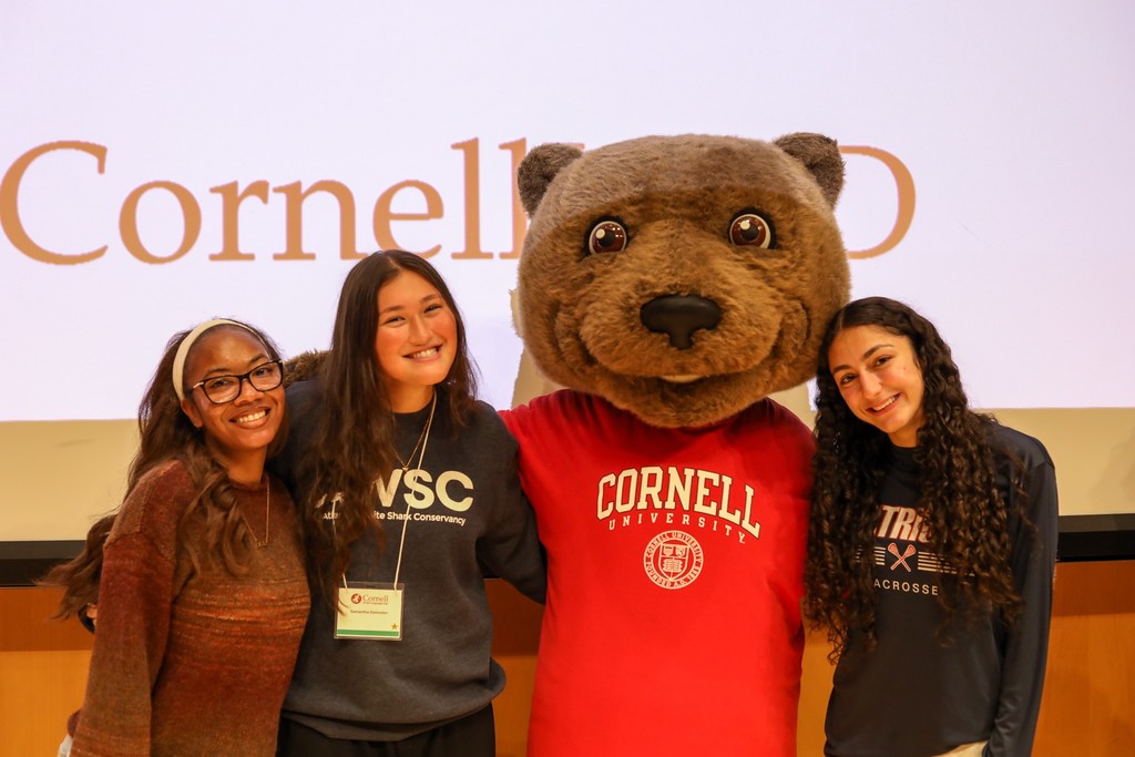 three bhs students pose for photo with cornell university mascot