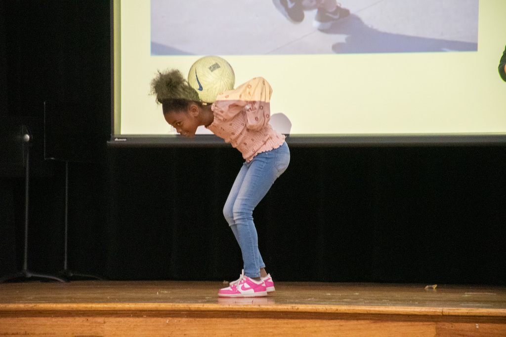 wilson student balances soccer ball behind her head