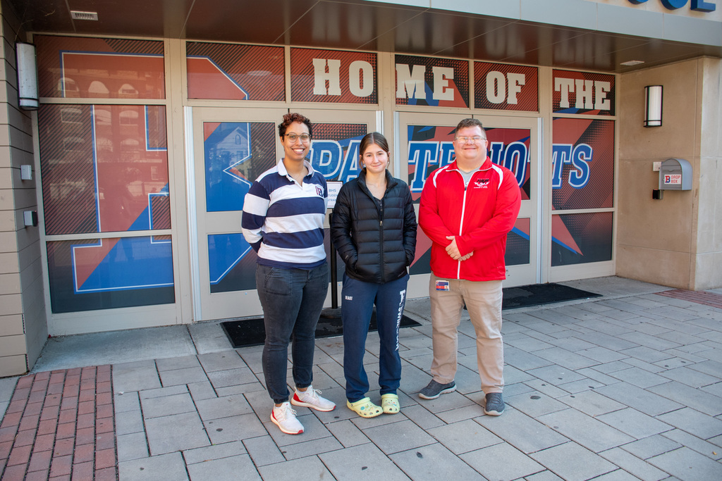 frances miller poses for photo with her coaches before heading to the state swim tournament
