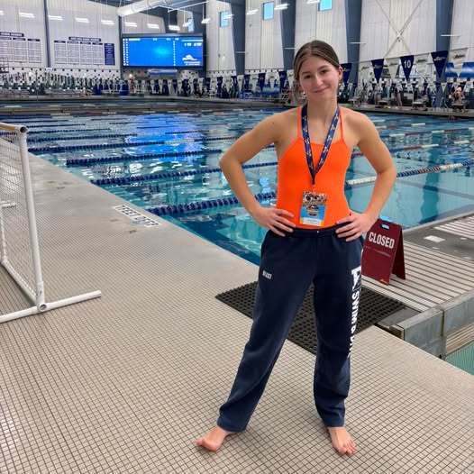 frances miller poses for photo on pool deck at the state championships