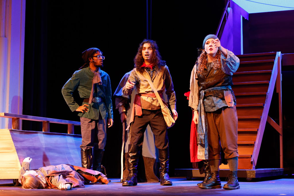 three students dressed as pirates performing in "treasure island"
