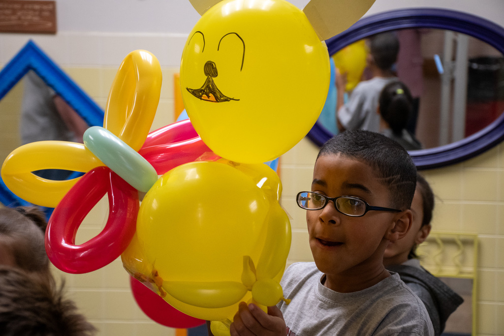 mann student hold balloons during balloons over mann parade