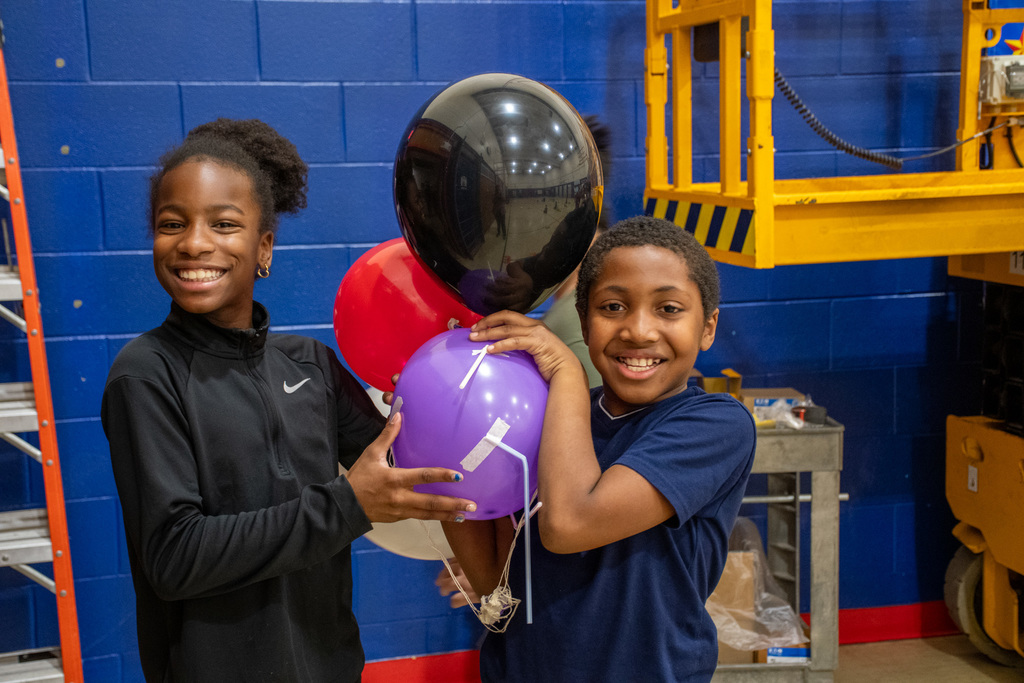 mann students hold balloons during balloons over mann parade