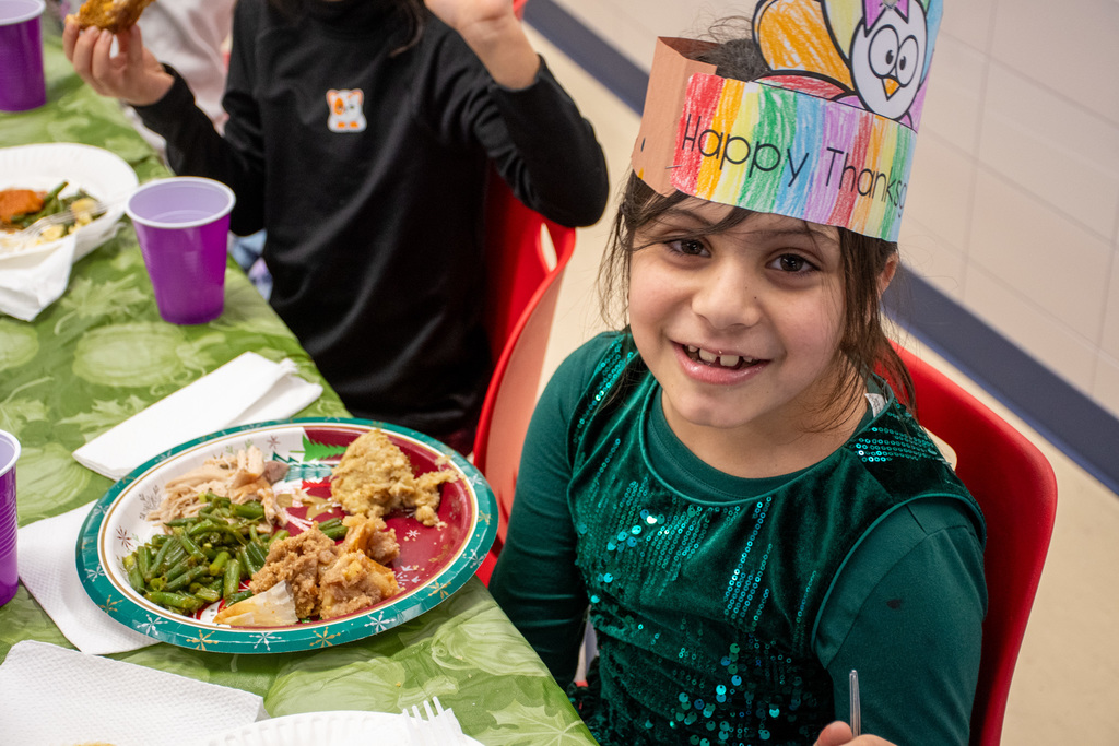 franklin student smiles for camera while eating thanksgiving feast