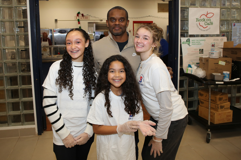 students and principal pose for photo at thanksgiving dinner