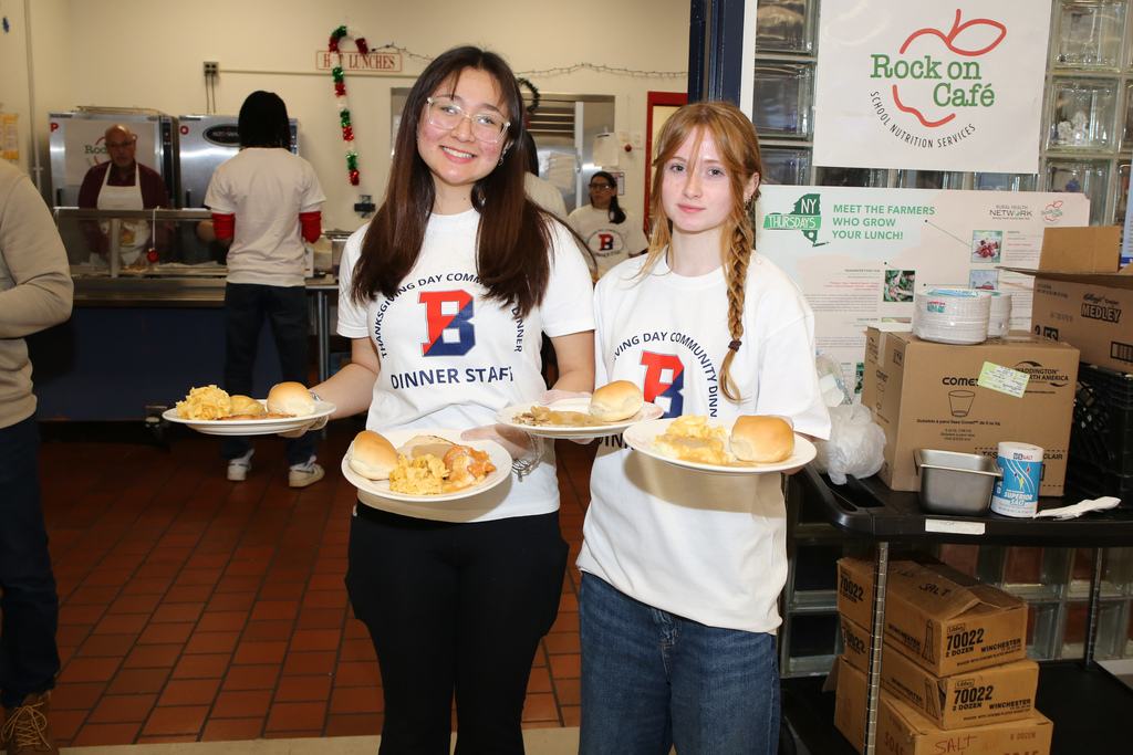bhs students holding plates of food at thanksgiving dinner