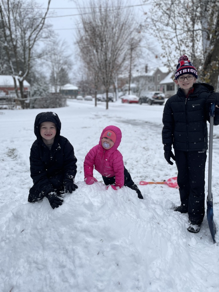 three students play in the snow