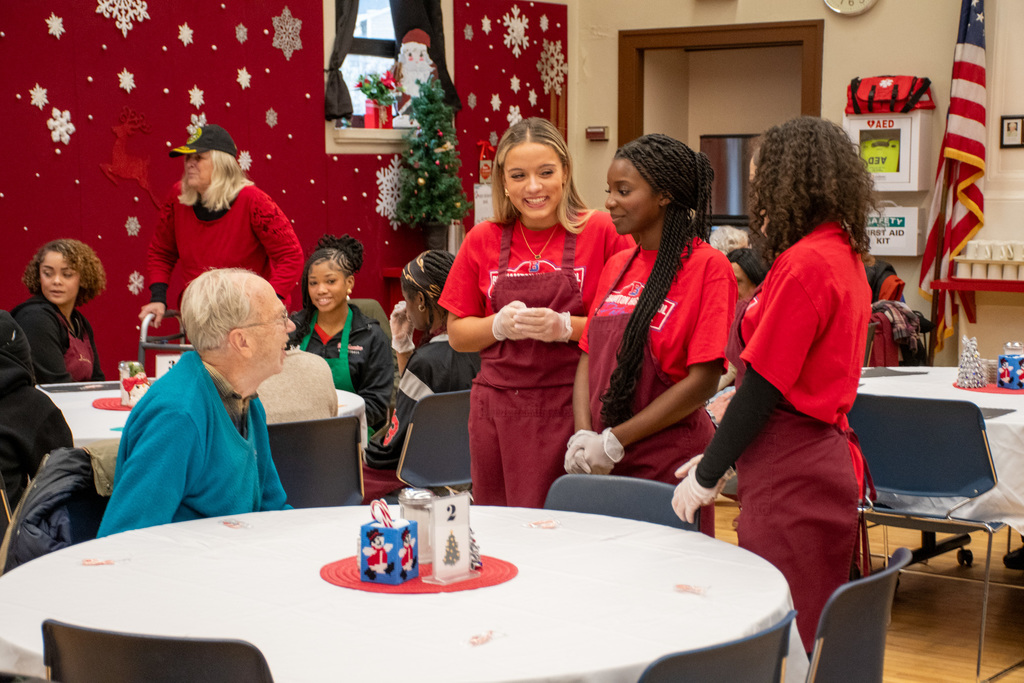 binghamton cheerleaders talk to man sitting at table