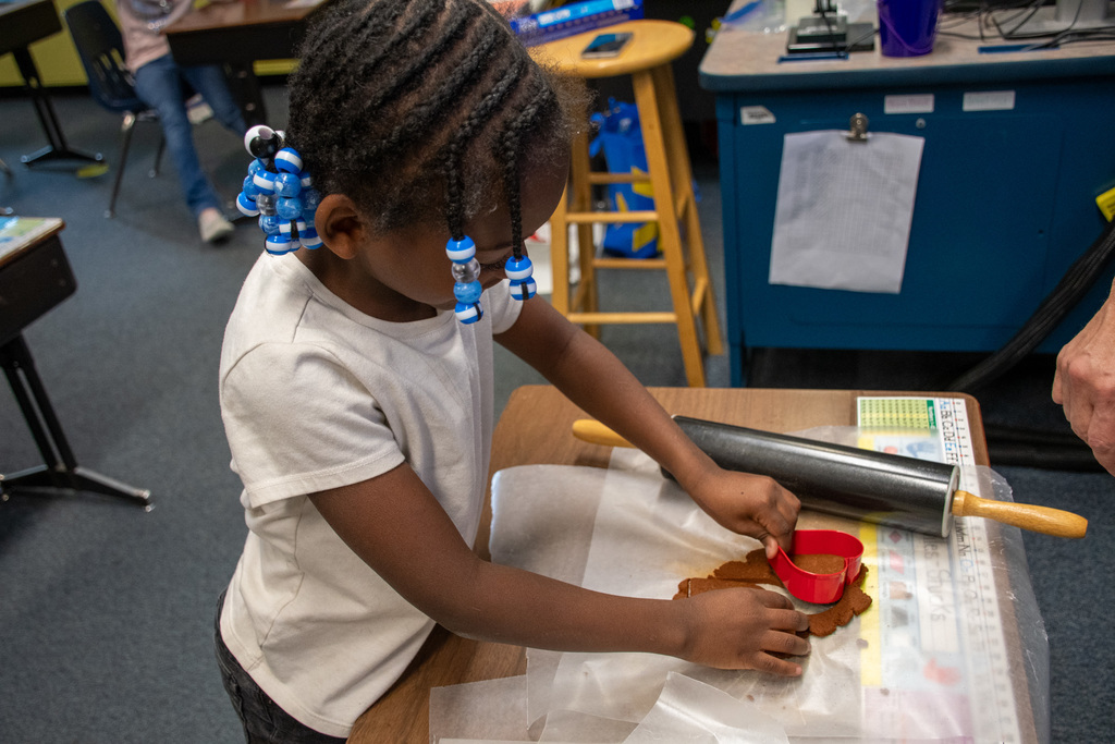 student cuts out shape from dough