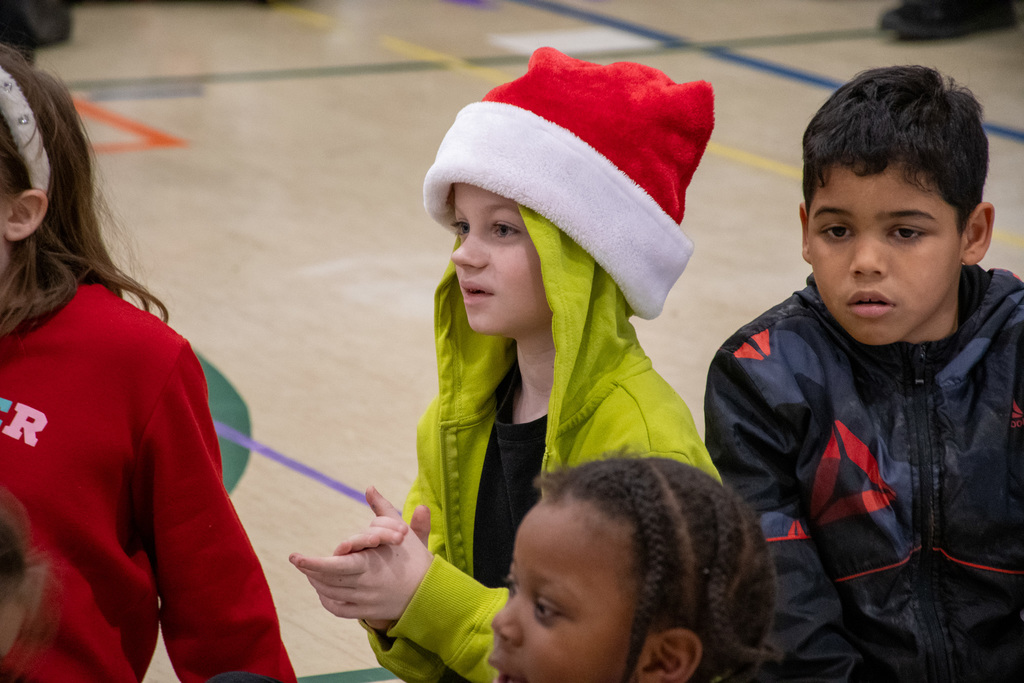 horace mann student wearing holiday hat claps during assembly