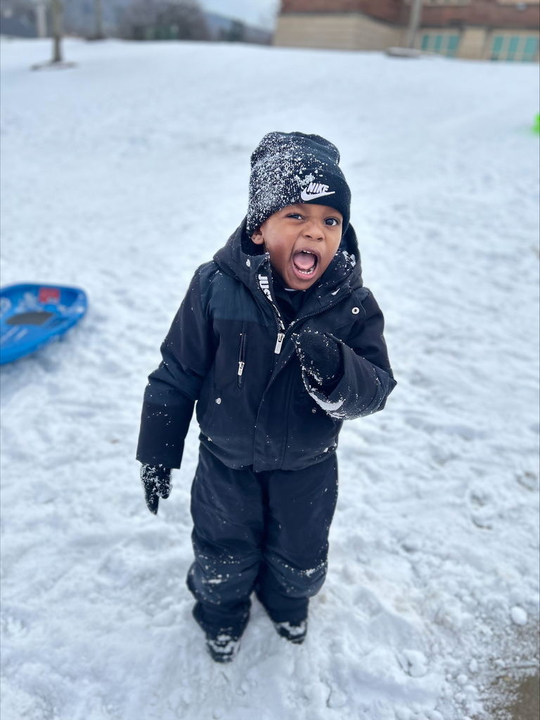 pre k student playing in snow and posing for camera