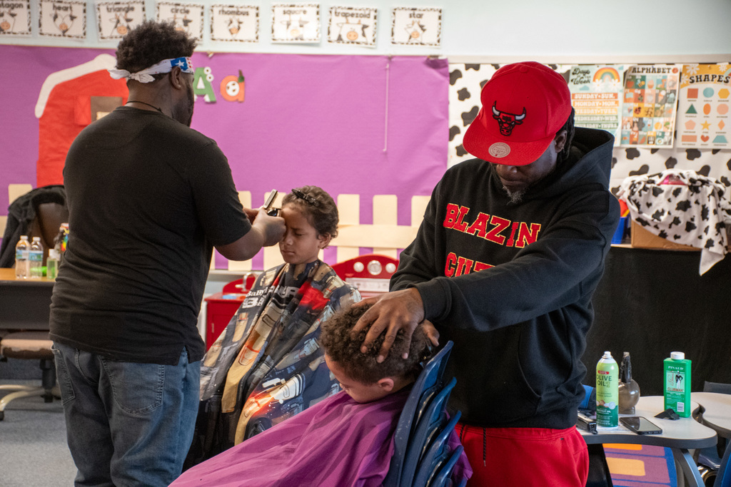 barbers cutting students' hair