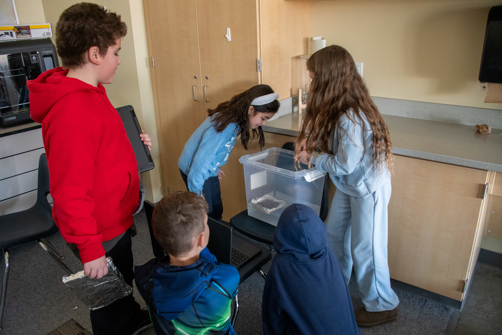 students add pennies to their floating boat