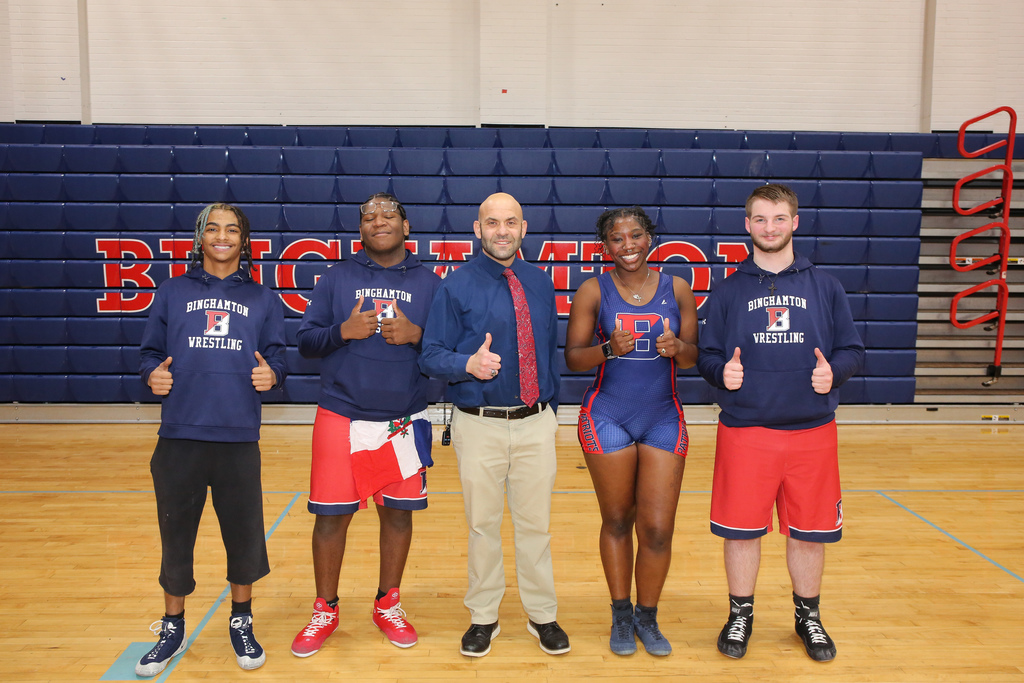senior wrestlers and coach give thumbs up for the camera