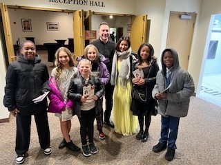 students with philharmonic conductor and soloist