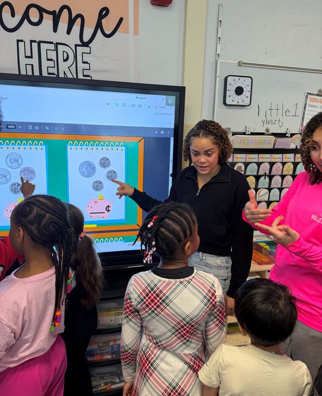 bhs visions fcu intern points at images of coins on a screen