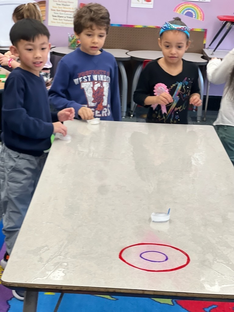 mann students play mini curling on a table top