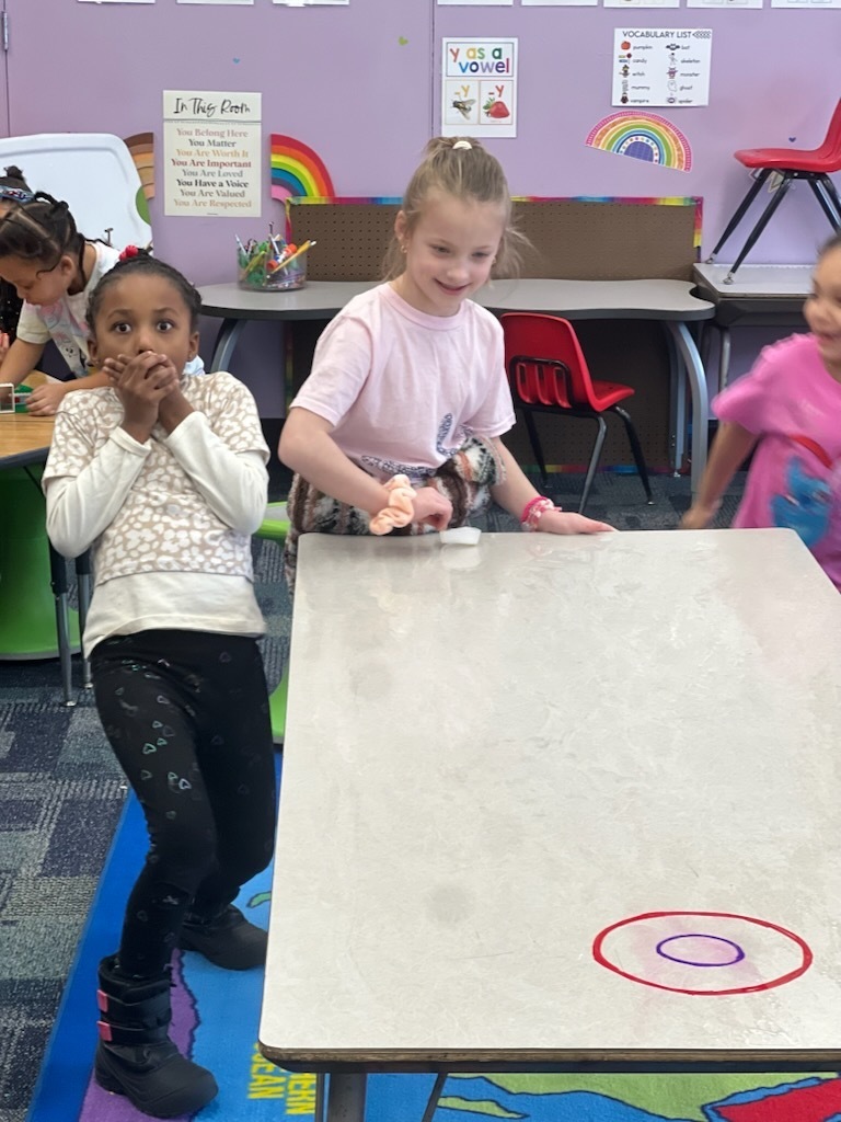 mann students play mini curling on a table top