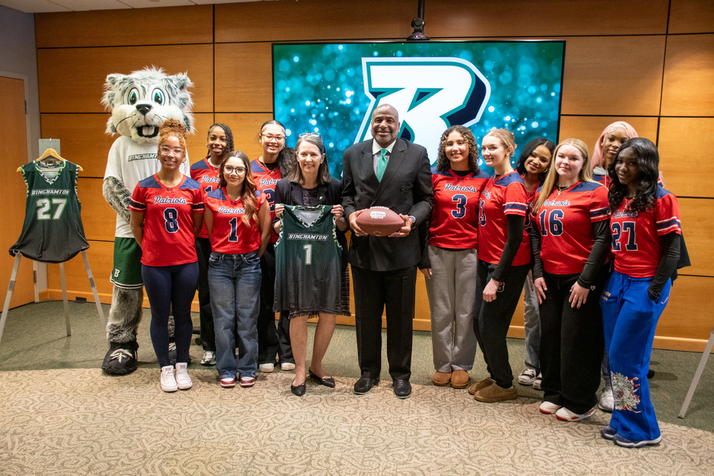binghamton high school flag football athletes pose for photo with binghamton university president and university athletic director