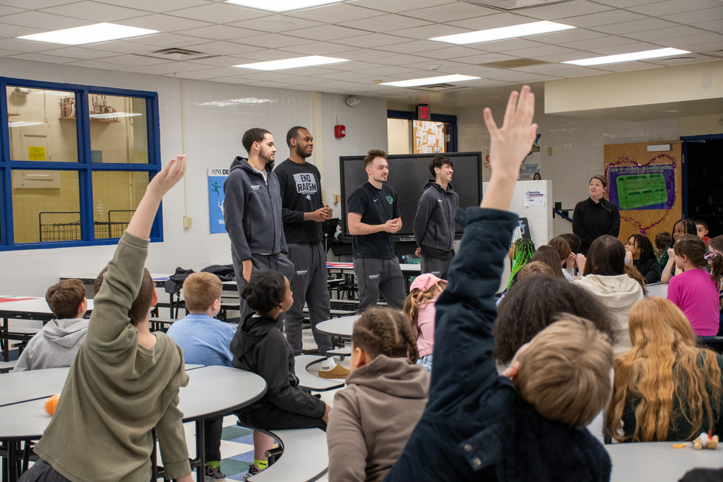 thomas jefferson students raise hands to ask binghamton university men's basketball players questions