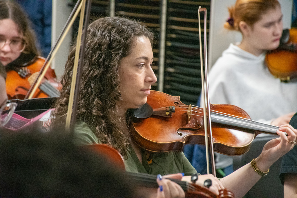 emily garrison plays violin while rehearsing with binghamton high school orchestra students