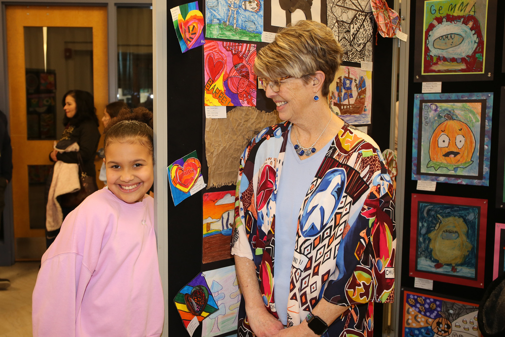 student and teacher pose for photo at district art show