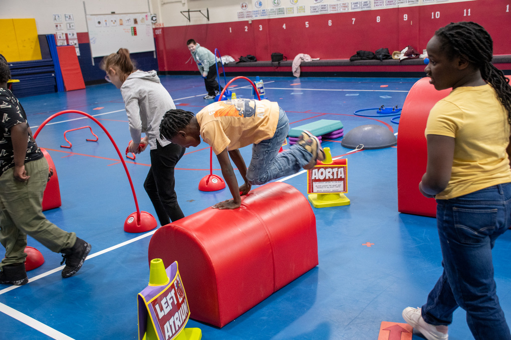 student jumps over mat as part of heart smart obstacle course