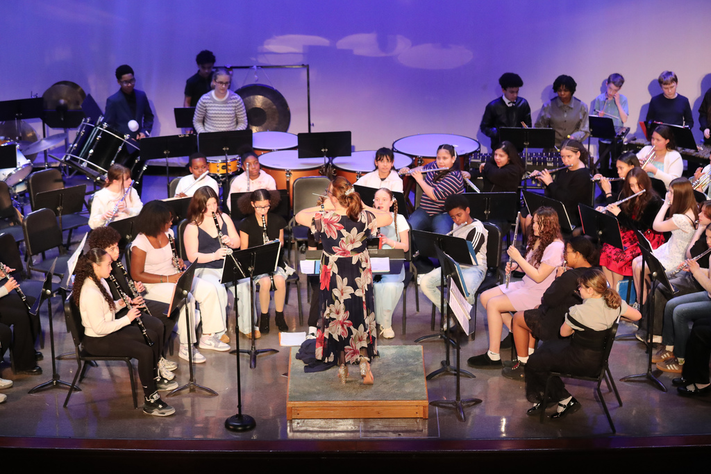 teacher conducts student band on EMS stage