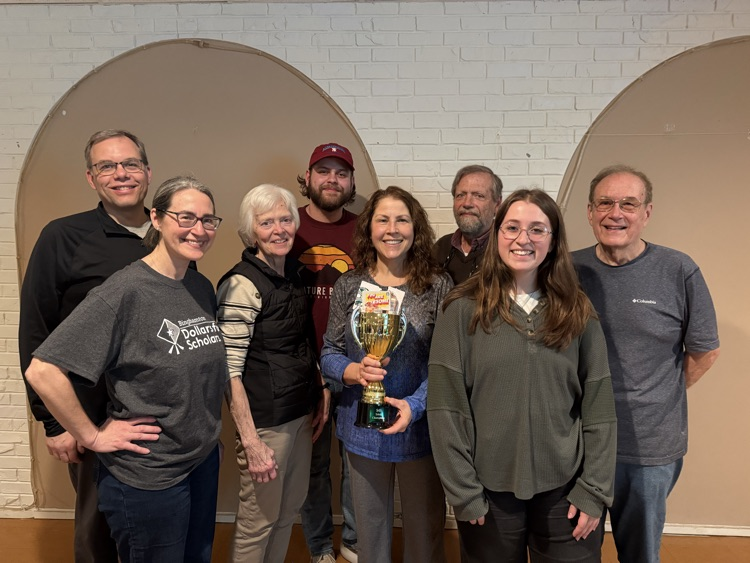 group of people posing with trophy filled with smarties candies