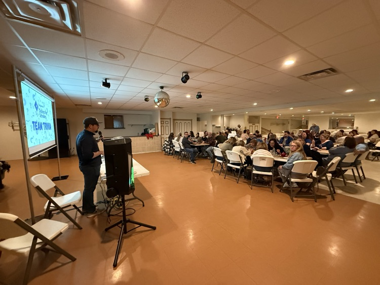 people sitting at tables playing trivia