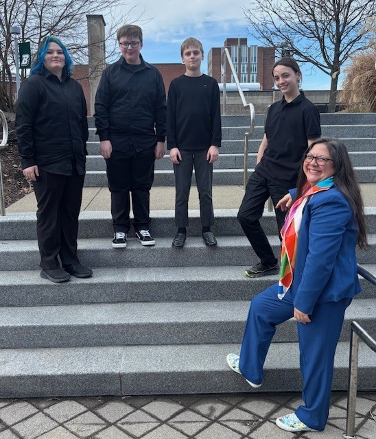 west middle school band students and teacher pose for a photo on steps at binghamton university