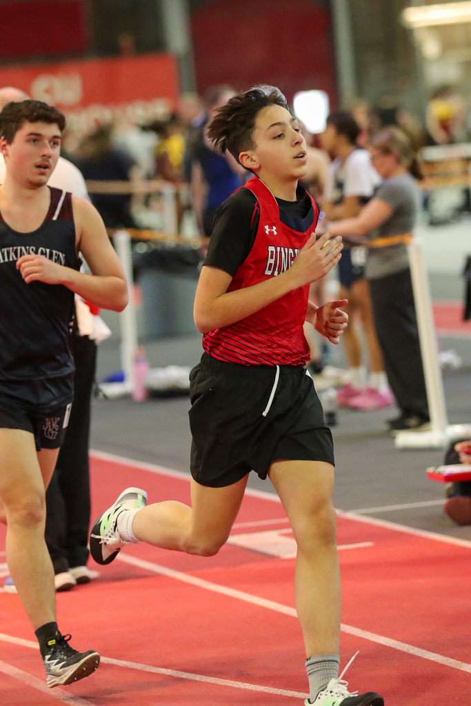 student runs during indoor track meet
