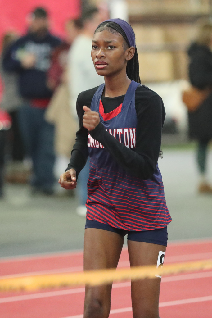 student runs during indoor track meet