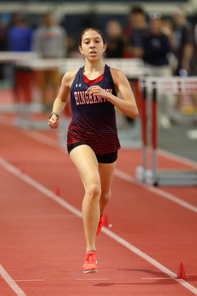 student running at indoor track meet