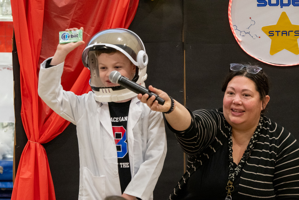horace mann second grade student wearing astronaut helmet holds up a pack of gum