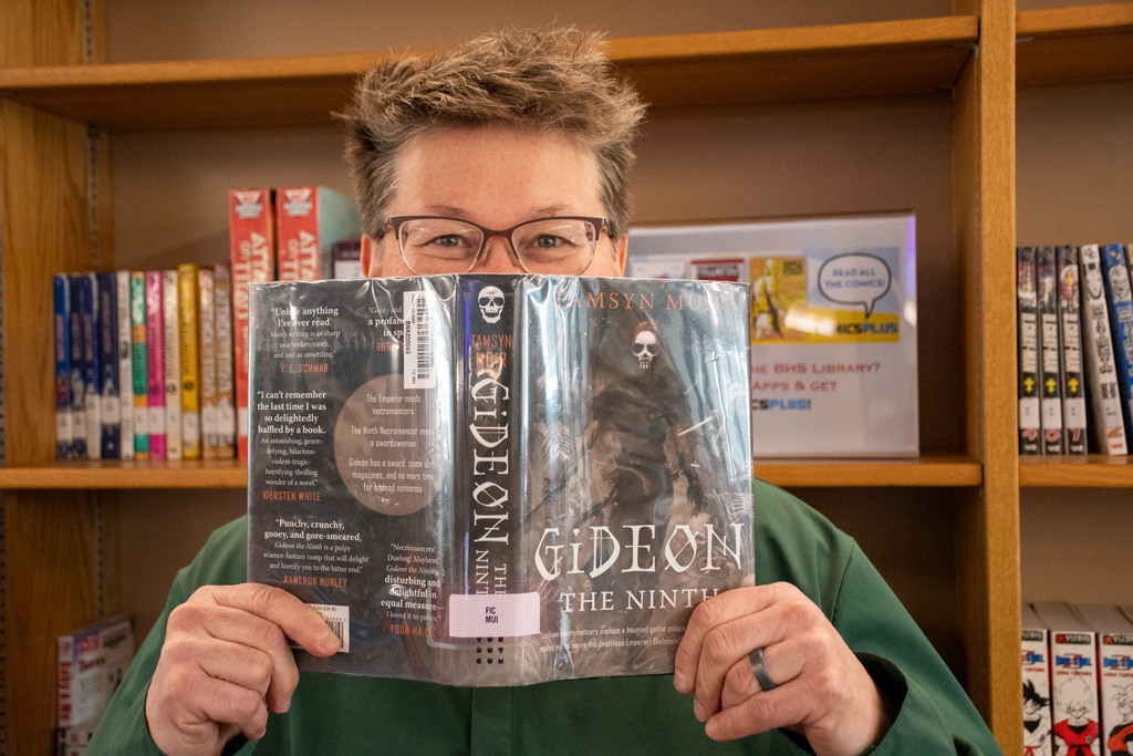 school librarian holds up "gideon the ninth" by tamsyn muir