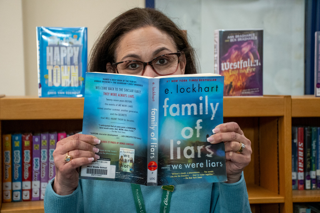 school librarian holds up "family of liars" by e. lockhart