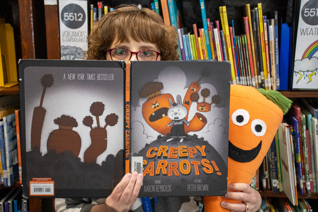 school librarian holds up "creepy carrots" by aaron reynolds