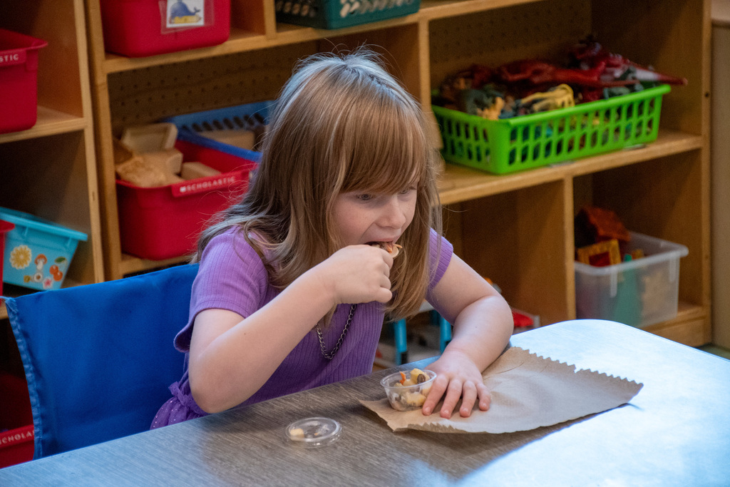 kindergarten student eats fruit and veggie salad