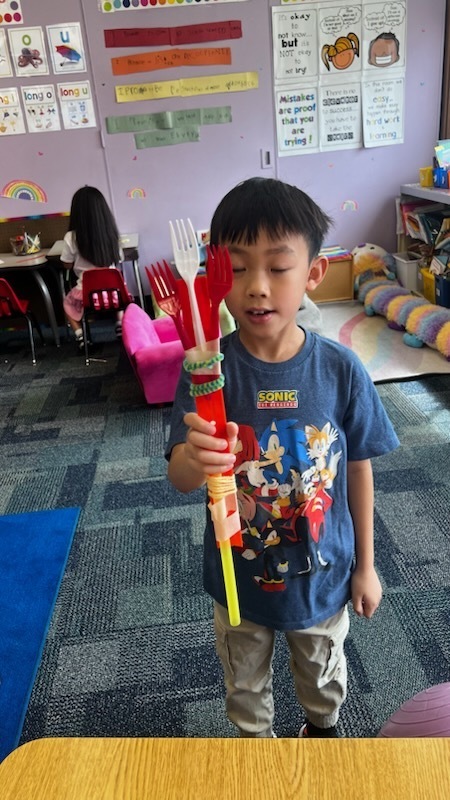 student shows off homemade back scratcher