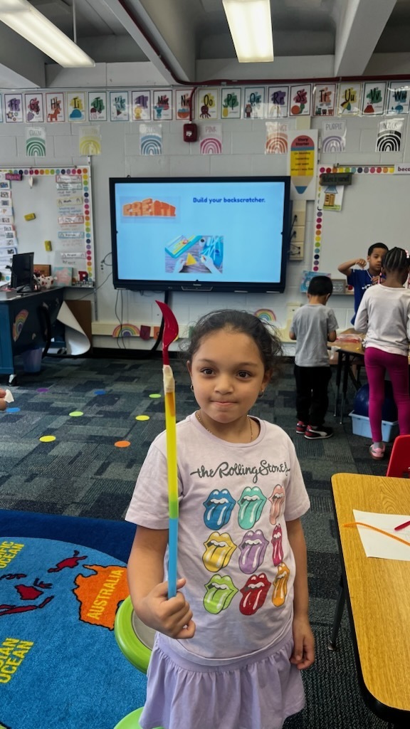student shows off homemade back scratcher